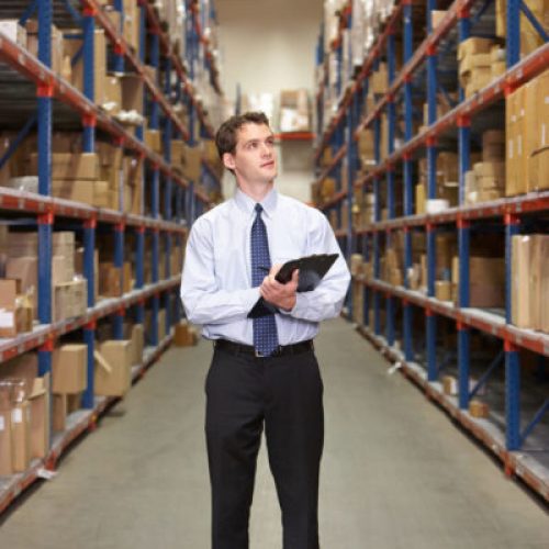 Manager In Warehouse With Clipboard